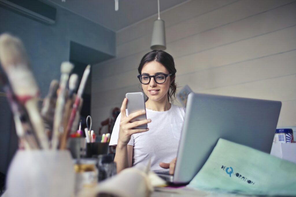 Mujer revisando su celular en su lugar de trabajo