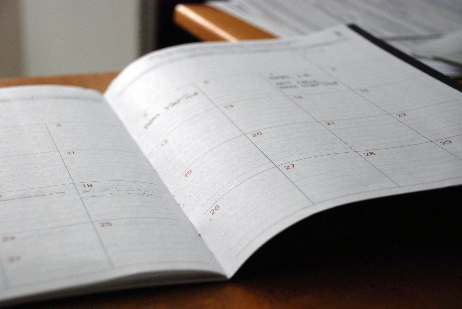 Agenda mensual abierta sobre un escritorio de madera